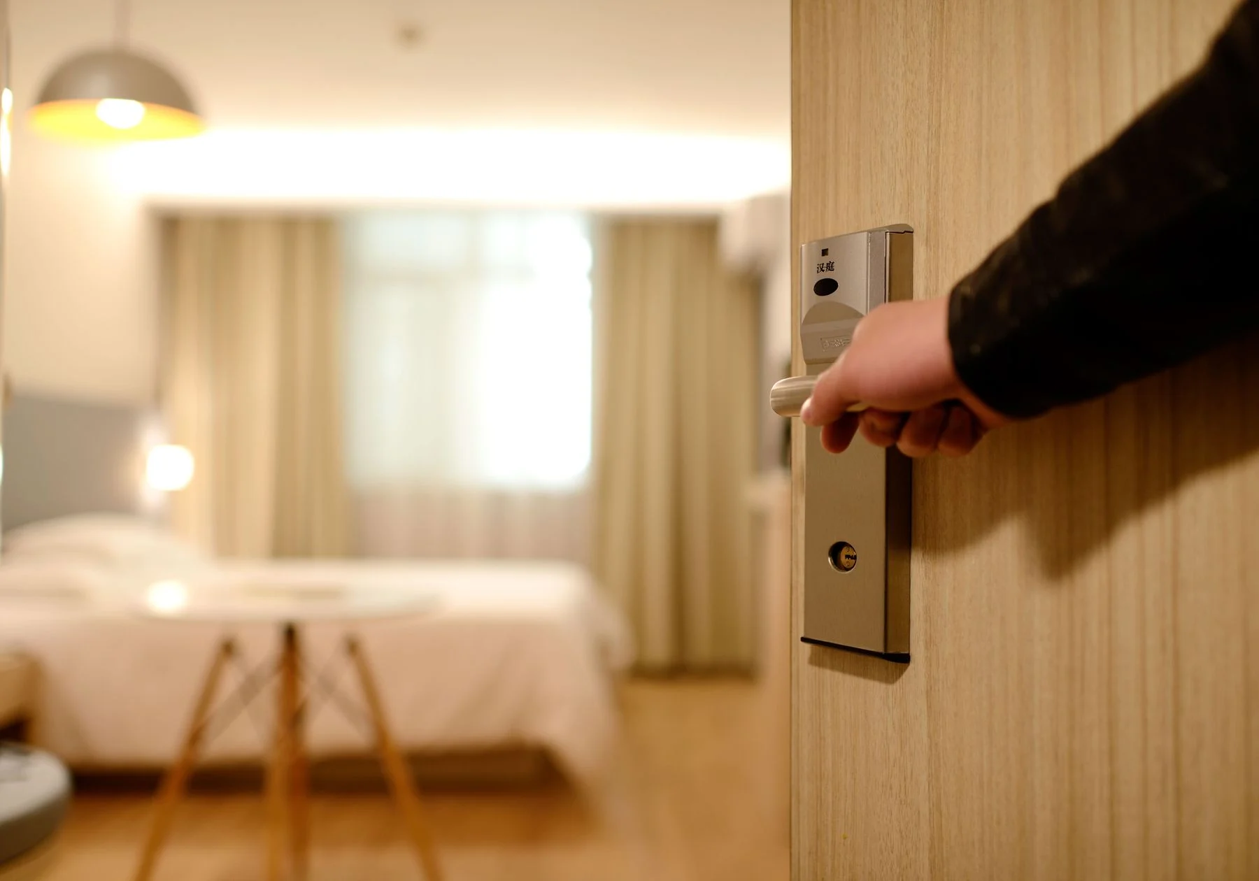 A guest opening a door into a prepared room